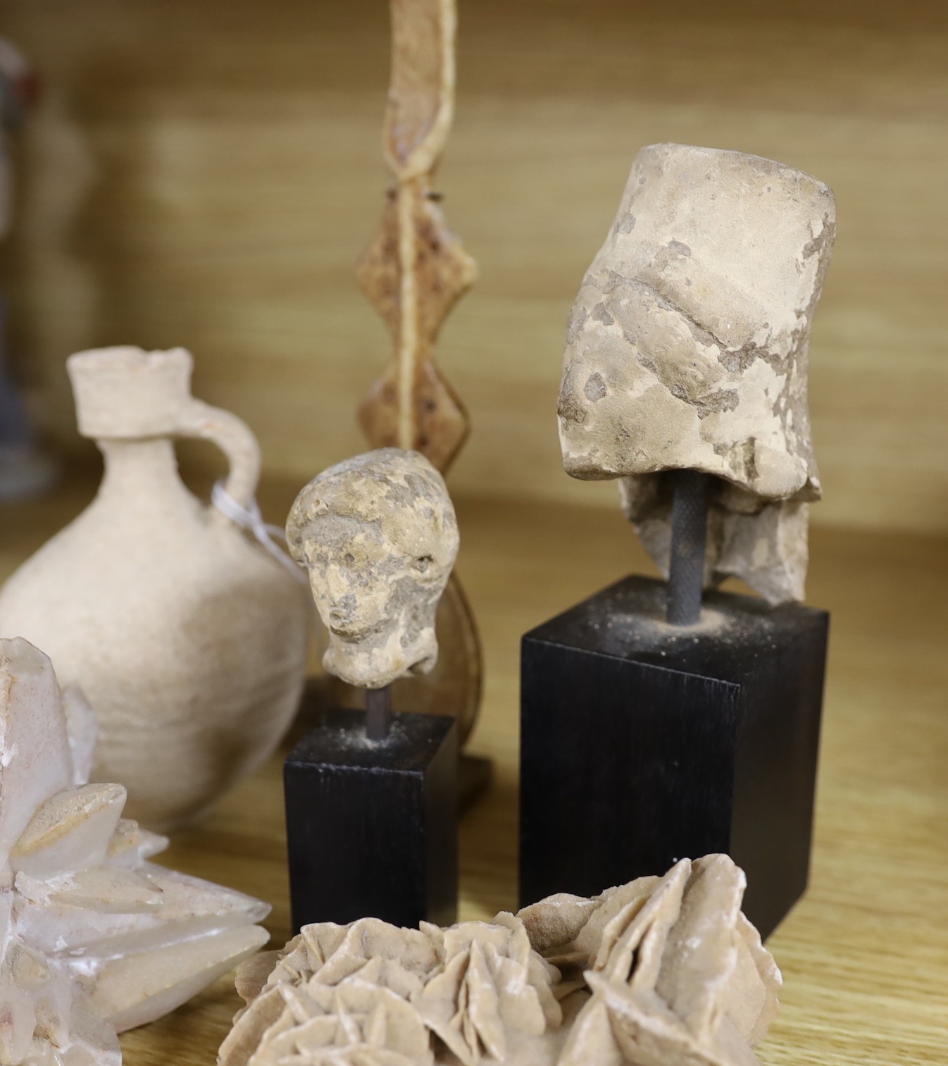 A Hellenistic terracotta figure head, a Pre-Columbian style mask on stand, a Greek vessel, together with others, tallest 22cm